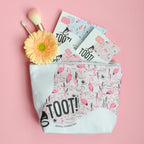 Makeup bag with flamingo design, 'TOOT!' text, and a flower on a pink background