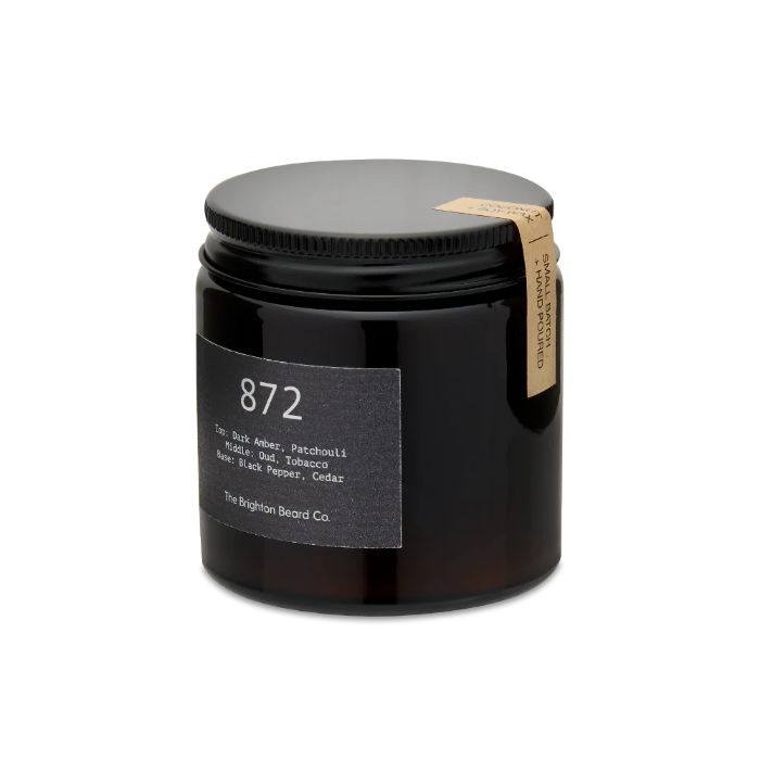 Candle in a black jar with a label on a white background