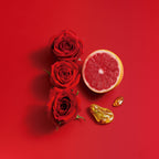 Red roses and a halved grapefruit on a red background