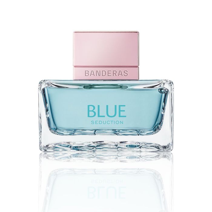 Thick glass perfume bottle with blue juice and rose cap on a white background