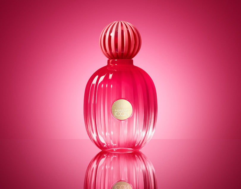 Pink perfume bottle with gold cap on a pink background