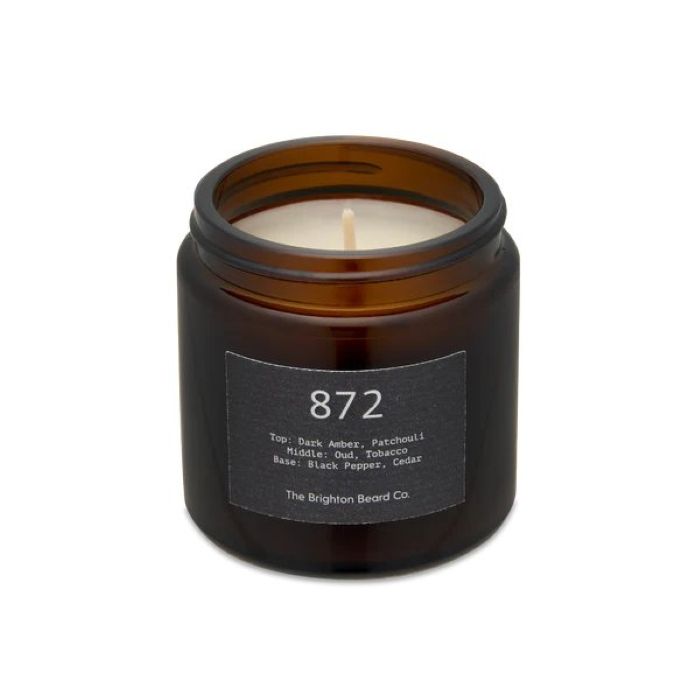 Brighton Beard white candle in a brown glass holder on a white background with neutral labels