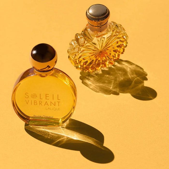 Two perfume bottles on a yellow background, one labeled 'Soleil Vibrant'.