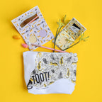 Cosmetic pouch with animal print and 'TOOT!' branding on a yellow background