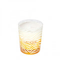 Candle in a Lalique container with wavy design on a white background